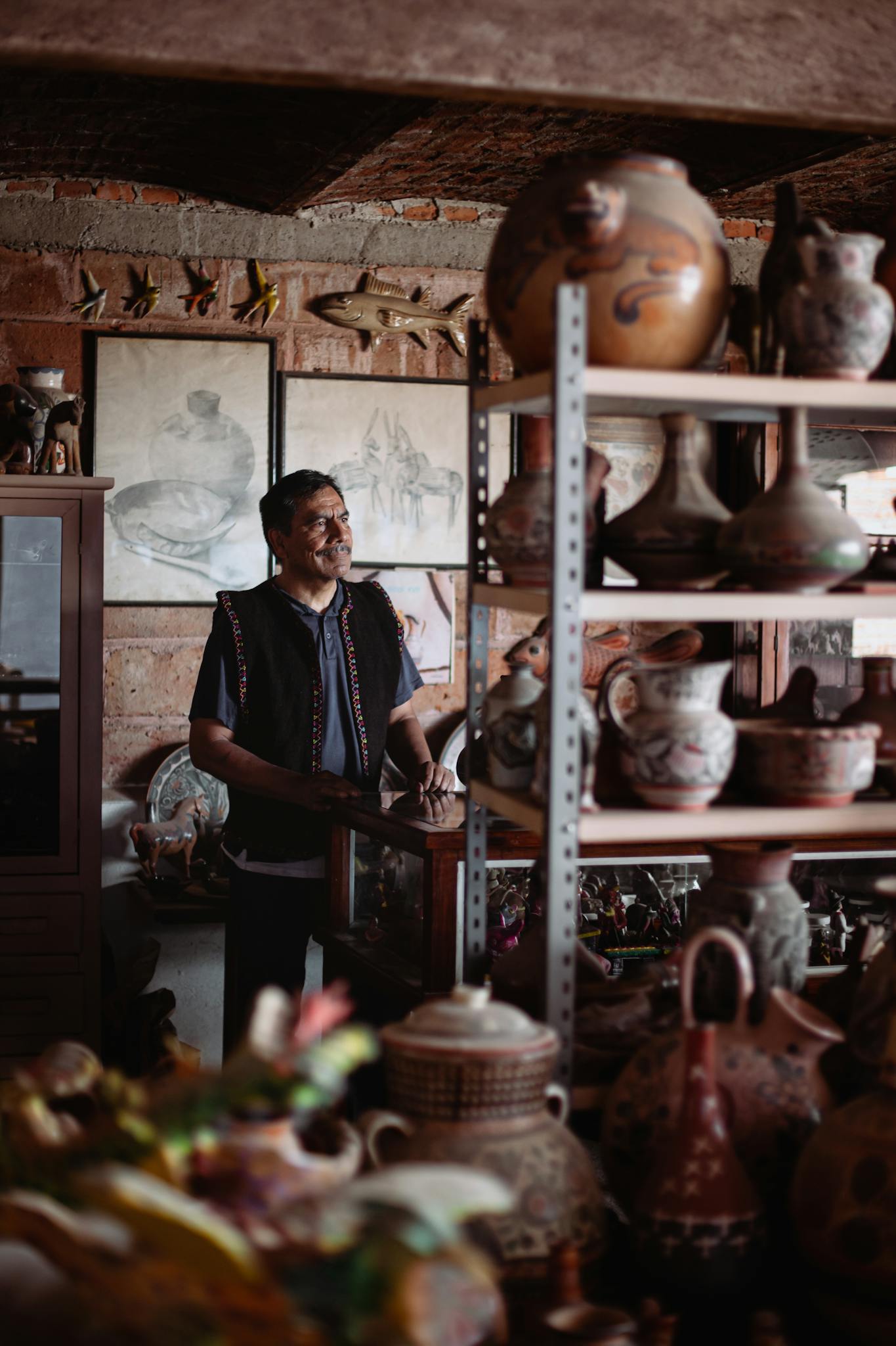 A skilled artisan surrounded by handmade pottery in a cozy workshop, showcasing craftsmanship.