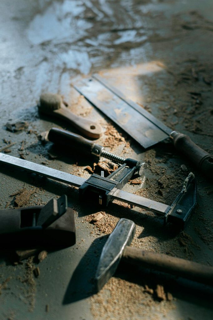 Flat lay of vintage carpenter tools and wood shavings in a workshop.